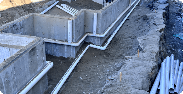 A concrete wall featuring integrated pipes, illustrating a complex drain system design