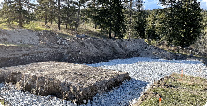 A large pile of rocks and gravel in a field, indicating foundation excavation work in progress