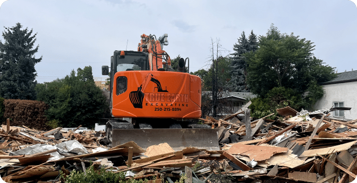 An excavator demolishing a house, showcasing full-scale demolition in action