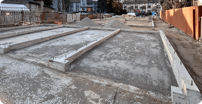 A concrete foundation is being constructed in a backyard, showcasing the slab preparation process