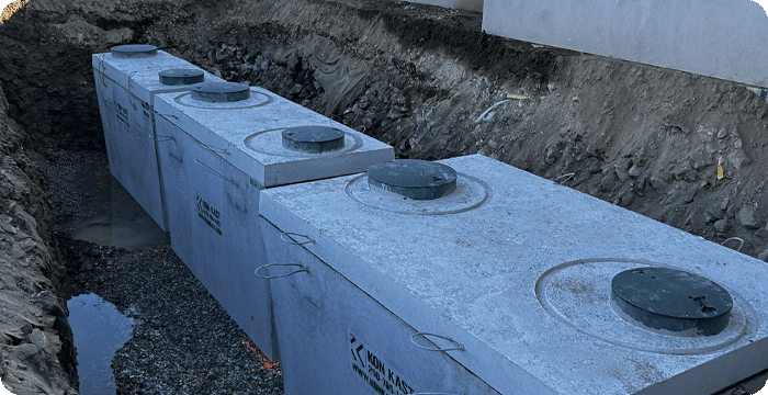 A cluster of concrete septic tanks installed in the ground, showcasing their functional design and placement